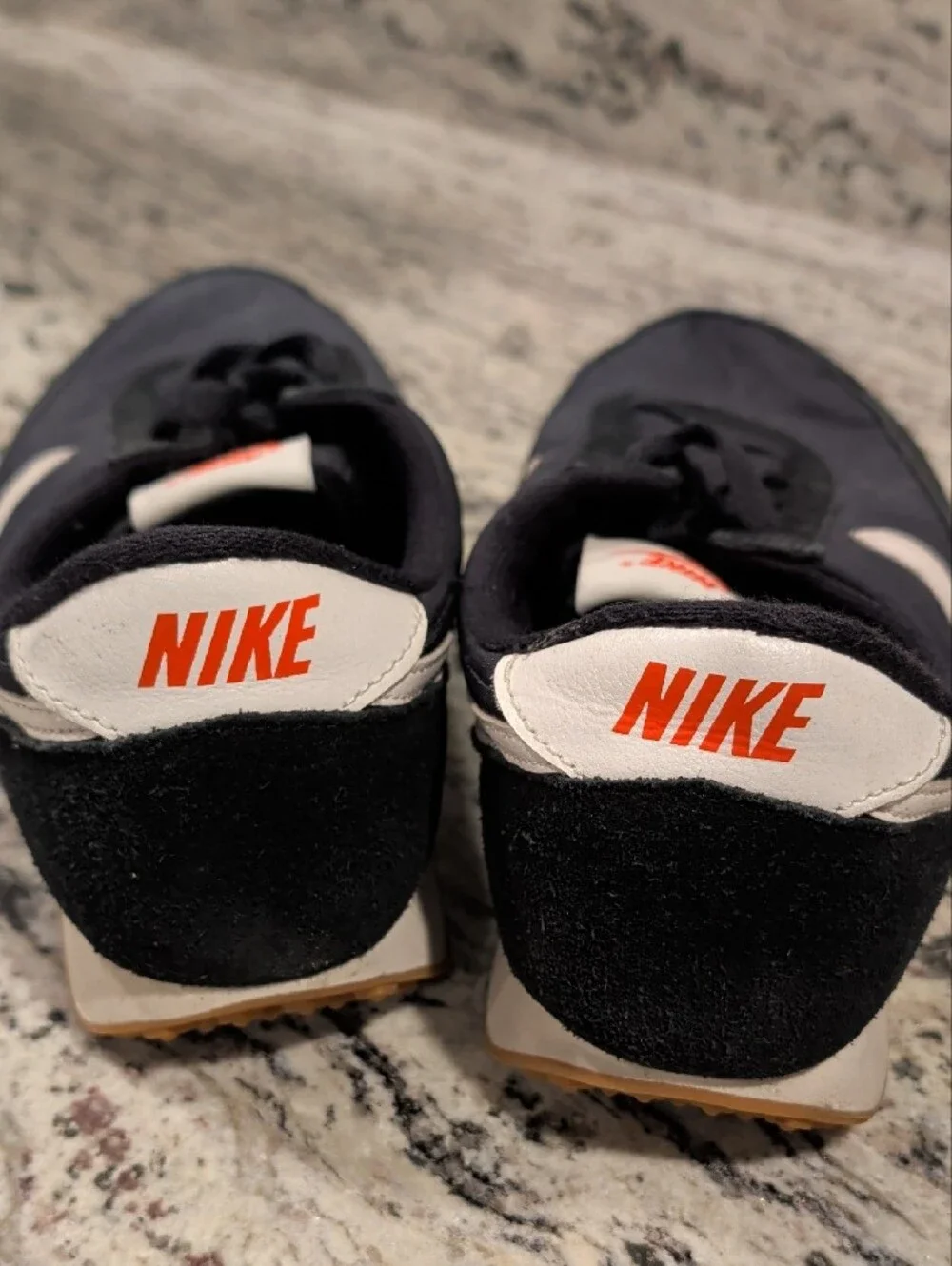 Nike Black Sneakers with White Swoosh and Orange Tongue Logo